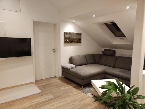 ein Wohnzimmer mit einem Sofa und einem Flachbild-TV in der Unterkunft Emmerich s neu errichtete DG-Wohnung in Bad Wildungen