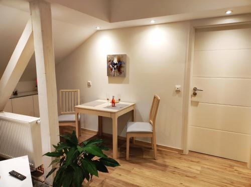 een kamer met een tafel en stoel en een deur bij Emmerich s neu errichtete DG-Wohnung in Bad Wildungen