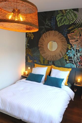 - une chambre dotée d'un grand lit blanc et d'une fresque murale dans l'établissement Les Briochines - Cocon cosy en plein centre-ville, à Saint-Brieuc