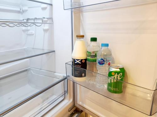 un frigorifero aperto con bottiglie di latte e soda di Modern Studio apartment in Newcastle upon Tyne a Newcastle upon Tyne