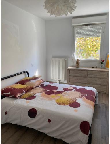 - une chambre dotée d'un lit avec un couvre-lit floral dans l'établissement Bel appartement duplex tramway à proximité, à Eysines