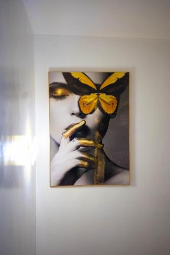 a picture of a woman with a butterfly on a wall at Morak Homes - Luxury 4 bed home with PS5, 24hrs electricity, Super fast Wifi, Snooker, Games room - in a secured estate in Abuja