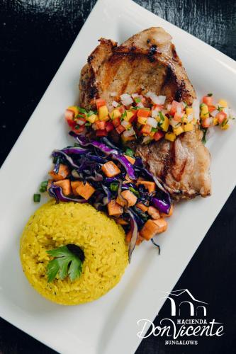 a plate of food with meat and rice and vegetables at Hacienda Don Vicente Bungalows-Tarapoto in Tarapoto