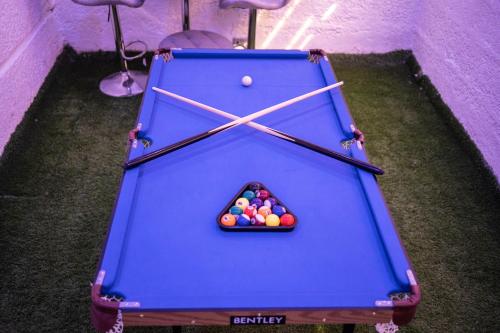 a blue pool table with balls in the middle at Morak Homes - Luxury 4 bed home with PS5, 24hrs electricity, Super fast Wifi, Snooker, Games room - in a secured estate in Abuja