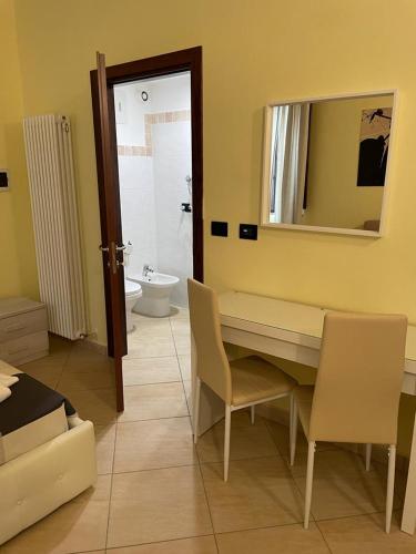 a room with a table and chairs and a bathroom at DIMORA AL SARACENO in Ferrara
