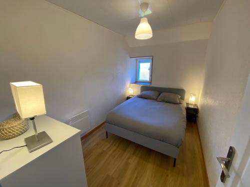 a small bedroom with a bed and a window at Un cocon en plein coeur du Jura - Chatillon in Châtillon