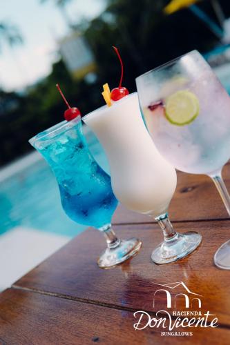 two cocktails sitting on top of a wooden table at Hacienda Don Vicente Bungalows-Tarapoto in Tarapoto