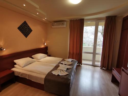 a hotel room with a bed with towels on it at HOTEL PARIS Relax Zone in Balchik