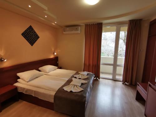 um quarto de hotel com uma cama com toalhas em HOTEL PARIS Spa area em Balchik