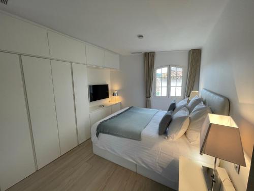 sypialnia z dużym łóżkiem i telewizorem w obiekcie Duplex Citadelle w Saint-Tropez