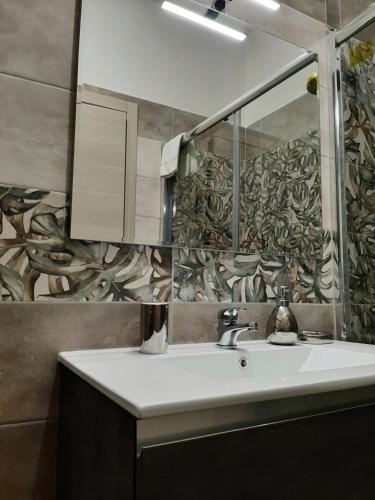 uma casa de banho com um lavatório e um espelho em Appartamento ALECATIA 2 em Roma