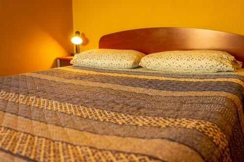 a bed with two pillows on top of it at La Casa del Sol Naciente in San Pedro de Atacama
