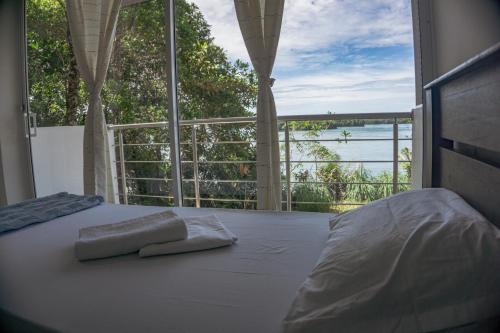 een slaapkamer met een bed en uitzicht op de oceaan bij La Manigua hostal in Buenaventura