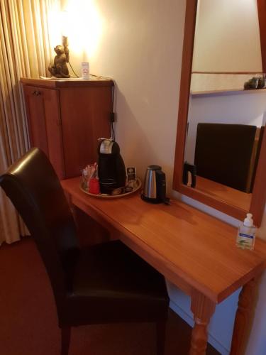 a desk in a hotel room with a mirror at Boetiek Hotel Marum in Marum