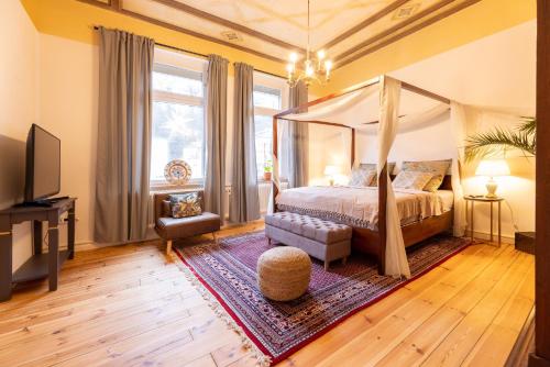 1 dormitorio con cama con dosel y TV en Zentral in Coburg: Exklusive Stadtwohnung – ideal für Gruppen en Coburg