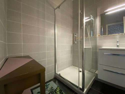 カルカソンヌにあるL'Appartement Jebari - Esprit loft Carcassonne proche cité médiéval et aéroportのガラスのシャワーと洗面台を備えたバスルーム