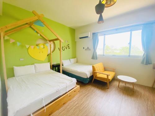 a small bedroom with two beds and a chair at 艾兒民宿 l 台東包棟 l 按訂房人數開放房間8-21人 in Taitung City