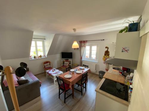 a kitchen and living room with a table and a couch at Coeur d'alsace in Kaysersberg