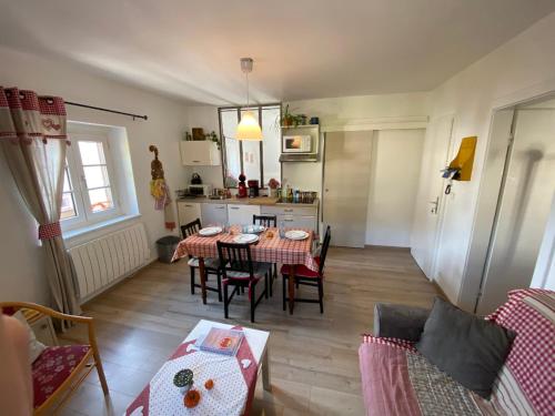 a living room with a table and chairs and a kitchen at Coeur d'alsace in Kaysersberg