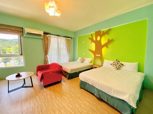 a bedroom with two beds and a tree mural on the wall at 艾兒民宿 l 台東包棟 l 按訂房人數開放房間8-21人 in Taitung City
