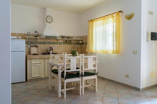 een keuken met een witte tafel en stoelen en een wastafel bij Lovely beach front apartment in Santa Maria in Santa Maria
