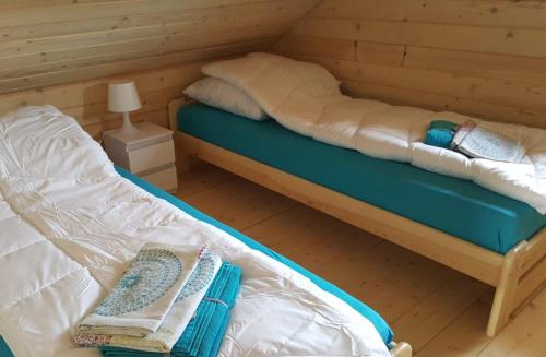 sypialnia z 2 łóżkami w drewnianym domku w obiekcie Słowińskie Widoki domek Natura, noclegi Smołdziński Las w Smołdzińskim Lesie