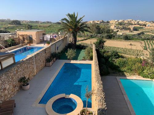 a villa with a swimming pool and a resort at Sunset Farmhouse in Għarb