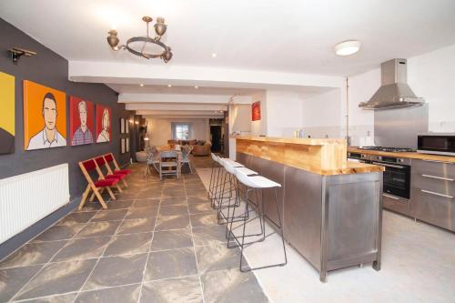 a kitchen with a bar with chairs and a table at higgihaus #5 Sleeps 14-16 Hens Stags Big Groups in Cardiff