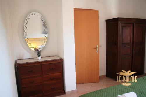 a room with a dresser and a mirror on a wall at Le Palme Holidays in Palmadula