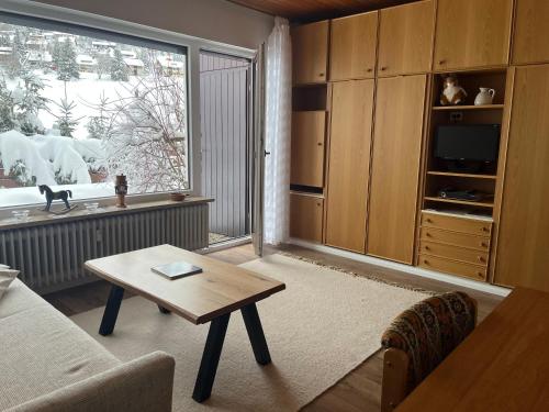 a living room with a table and a large window at Cozy Condo, Ski in and Out in Todtnau