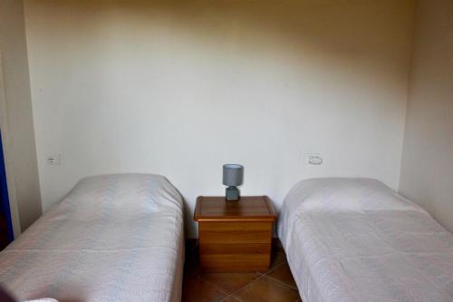 a bedroom with two beds and a wooden night stand at Résidence Itylon in Cargèse
