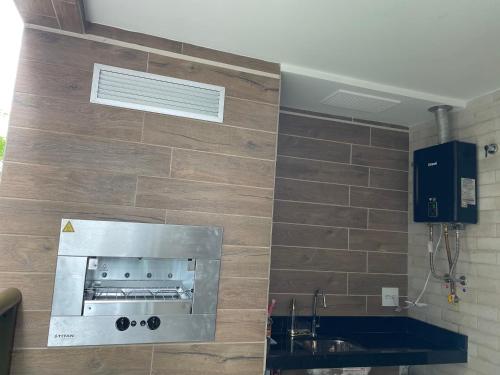 cocina con pared, fogones y fregadero en Condomínio novíssimo com total estrutura para vc, en Arraial do Cabo