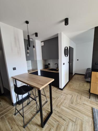 a kitchen and dining room with a wooden table in a room at Apartament Lake View z sauną i widokiem na jezioro in Kluszkowce
