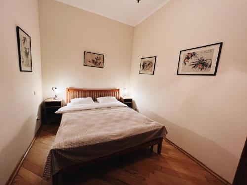 a bedroom with a bed and three pictures on the wall at Kyiv Gallery Apartment in Kyiv