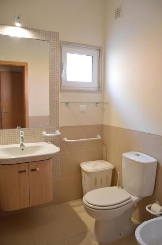 a bathroom with a toilet and a sink at Apartamentos Cabanas Golf in Tavira