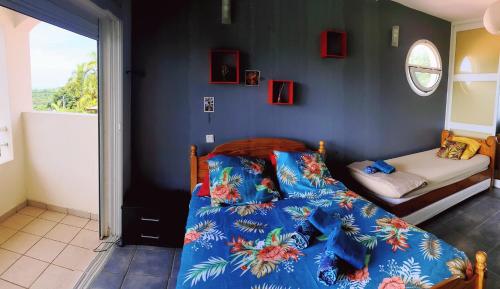 a bedroom with a bed and a small bedroom with a window at VILLA CAP détente et SPA in Saint-Louis