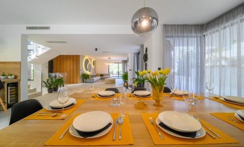 a dining room table with yellow napkins and plates on it at Villas Lucy - 1 Lemon -outdoor pool , 2 Cherry-indoor pool and 3 Plum-outdoor pool in Marina