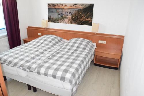 Ferienwohnung Gaffelschoner في Hohen Wieschendorf: غرفة نوم مع سرير وبطانية مقلية