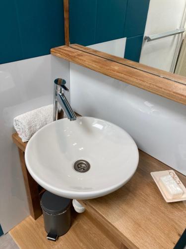 un lavabo blanc dans une salle de bain avec un miroir dans l'établissement Gite La Janiat, à Montigny-sur-lʼAin