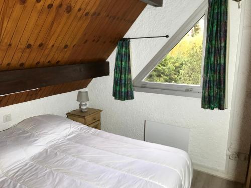 a bedroom with a white bed and a window at APPARTEMENT CAUTERETS POUR 4 PERSONNES AVEC PARKING in Cauterets