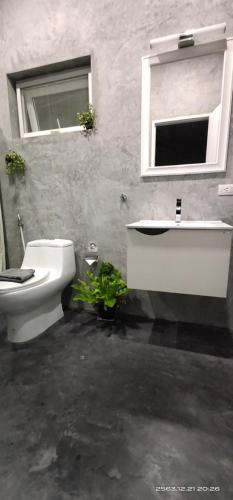 łazienka z umywalką, toaletą i oknem w obiekcie Swiss Bungalow Cha Am w mieście Cha Am