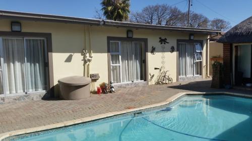 a swimming pool in front of a house at Genie's Nest 3 in Pretoria