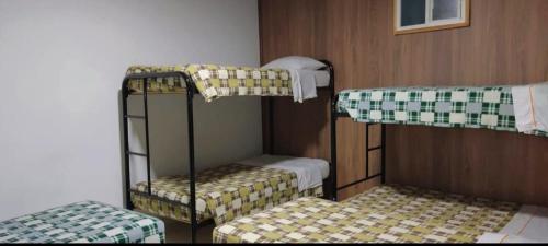 a room with three bunk beds in a room at Hotel Mónaco de Fusa in Fusagasuga