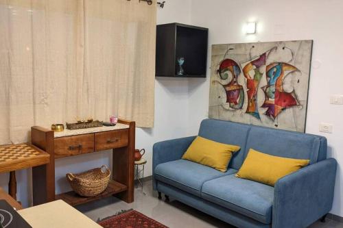 salon z niebieską kanapą i stołem w obiekcie סוויטה הילה במצובה w mieście Maẕẕuva