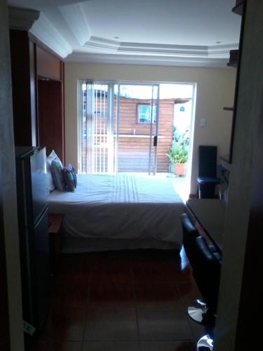 a bedroom with a bed and a large window at Genie's Nest 4 in Pretoria