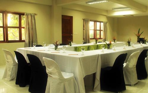 a room with a long table with white tables and chairs at Asia Grand View Hotel in Coron