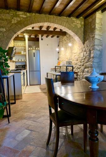 a kitchen and dining room with a wooden table with chairs at Le Antiche Mura in Semproniano