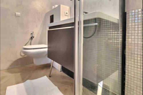 a bathroom with a toilet and a glass shower door at Beautiful Fully Renovated Centrally Located Studio in Monte Carlo