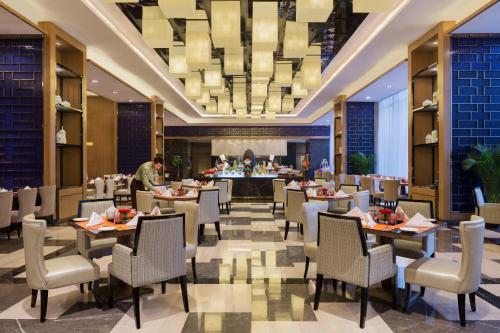 una sala da pranzo con tavoli e sedie in un hotel di Wanda Realm Nanchang a Nanchang