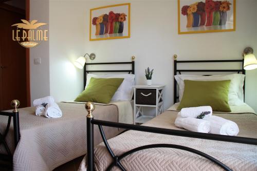 two beds in a room with green and white at Le Palme Holidays in Palmadula